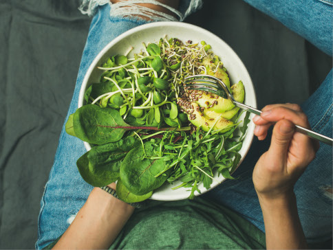 Man eating raw foods from white bowl