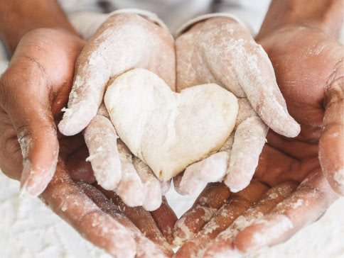 Father and daughter's hands kneading dough